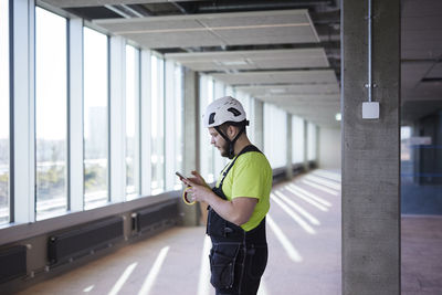 Worker using cell phone at building site