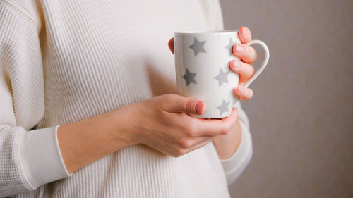 Close-up of hand holding coffee cup