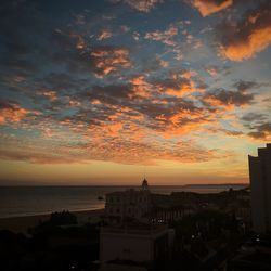 Scenic view of sea against cloudy sky during sunset