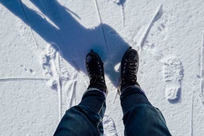 Low section of person standing on snow