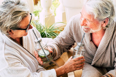 High angle view of couple drinking while sitting at home