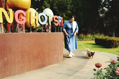 Full length of woman with dog against plants