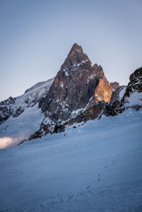 Low angle view of snowcapped mountain against sky