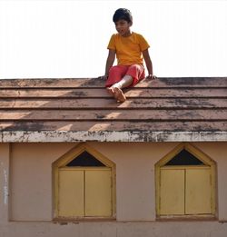 Low angle view of man on house against building
