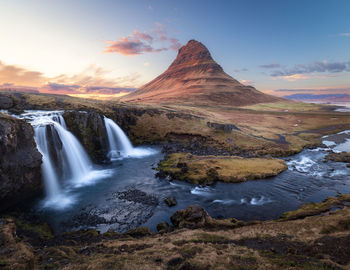 Scenic view of waterfall against sky