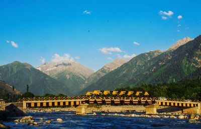 Arch bridge over river against mountains