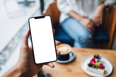 Close-up of hand holding mobile phone