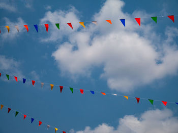 Low angle view of flags hanging against sky