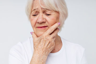 Senior woman gesturing against white background