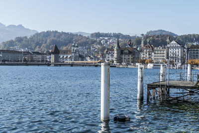 Sea by buildings against clear sky