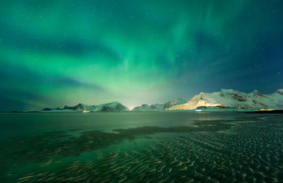 Scenic view of snowcapped mountains against sky at night