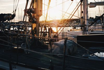 Boat moored at harbor during sunset