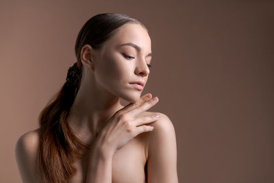 Close-up of young woman against black background