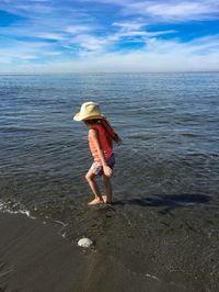 Rear view of man walking on beach