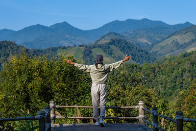 Rear view of man standing against mountain