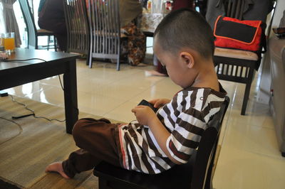 Boy using mobile phone while sitting in home