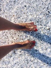 Low section of woman relaxing on sand at beach