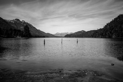 Scenic view of lake by mountains against sky