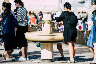 Rear view of people standing in city