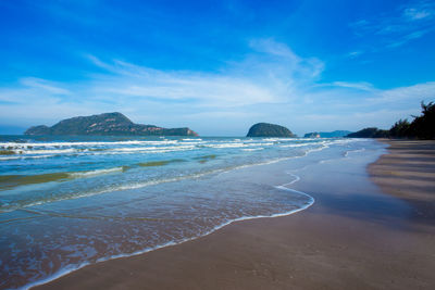 Scenic view of beach against blue sky