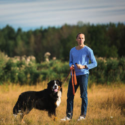 Man with dog standing on land