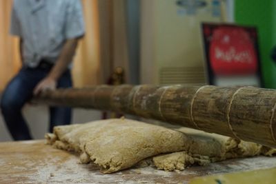 Midsection of man preparing dough