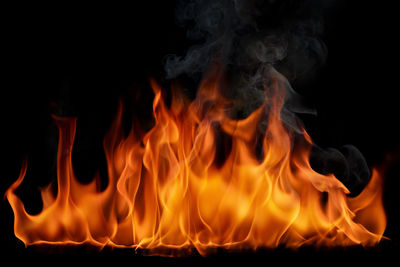 A burning flame and smoke on a black background