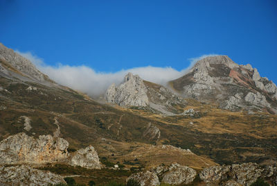 Scenic view of mountains against blue sky