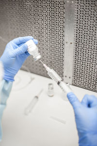 Cropped hands of dentist filling medicine into syringe