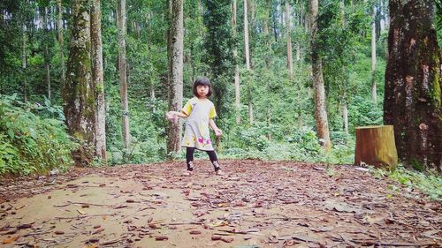 Full length of woman standing in forest