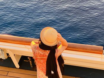 Rear view of woman wearing sun hat in cruise at sea during sunny day