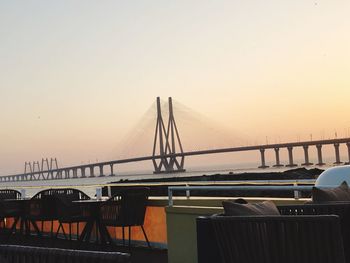 Suspension bridge against clear sky during sunset
