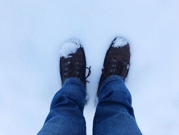 Low section of person standing on snow