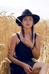 Woman in black dress and hat lying in a field