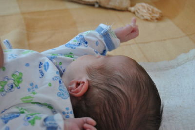 Close-up of cute baby lying on bed at home