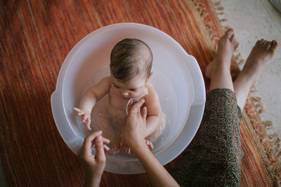 High angle view of mother bathing daughter