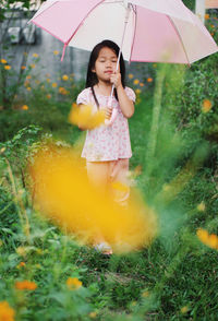 Full length of happy girl holding umbrella