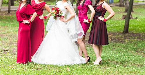 Low section of bride holding bouquet