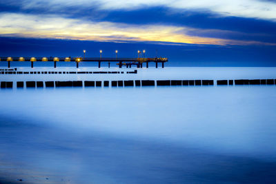 Pier over sea against sky during sunset