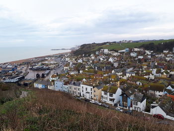 High angle view of town by sea against sky