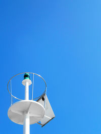 Low angle view of electric lamp against clear blue sky