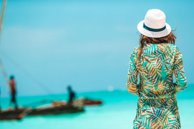 Rear view of woman standing against sea