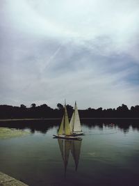 Boat moored on lake against sky