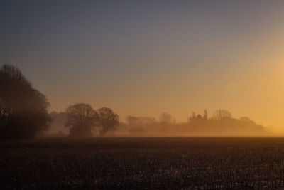 Scenic view of field against sky during sunset