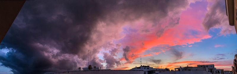 Low angle view of buildings against dramatic sky