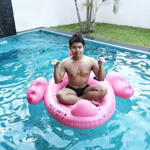 Man siting on inflatable ring in swimming pool