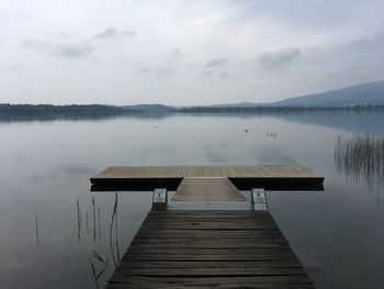 Pier over lake against sky