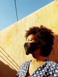 Portrait of woman against wall against clear sky