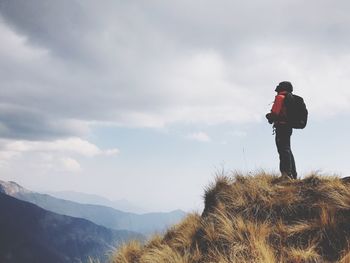 Woman standing on snow covered mountain against sky