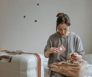 Woman with the baggage and passport at home, preparing t flight